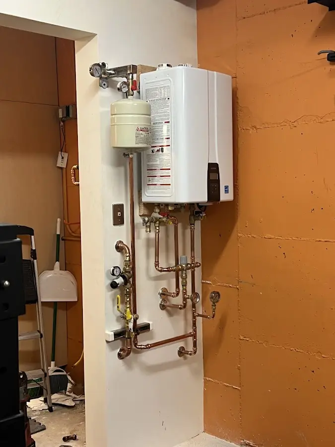 Plumbing technician inspecting water heater connections in Crystal Lake